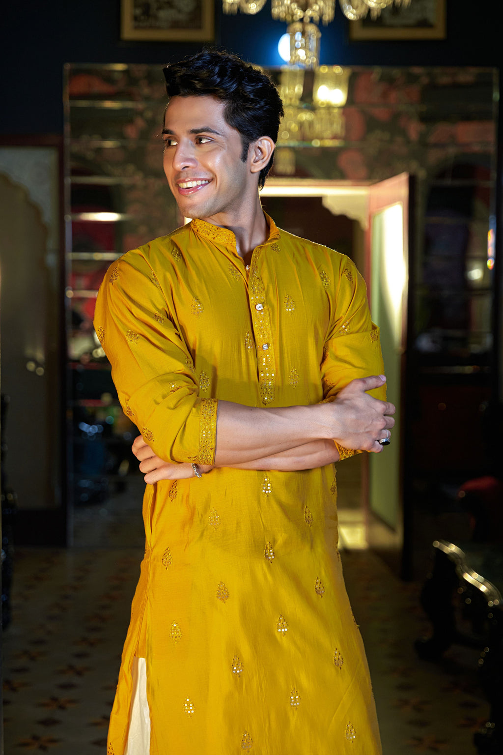 Indian man wearing a bright yellow kurta with embroidery work.